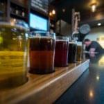 Craft beer flight lineup on a wooden brewery bar counter
