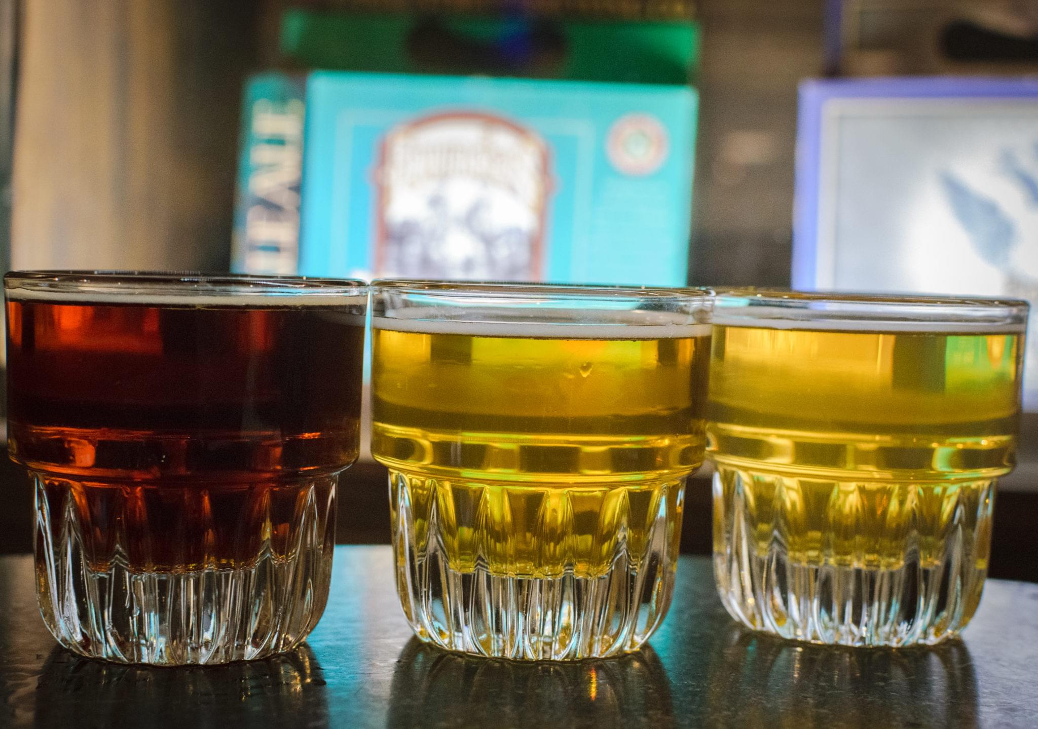 Multiple pints of beer lined up on bar counter