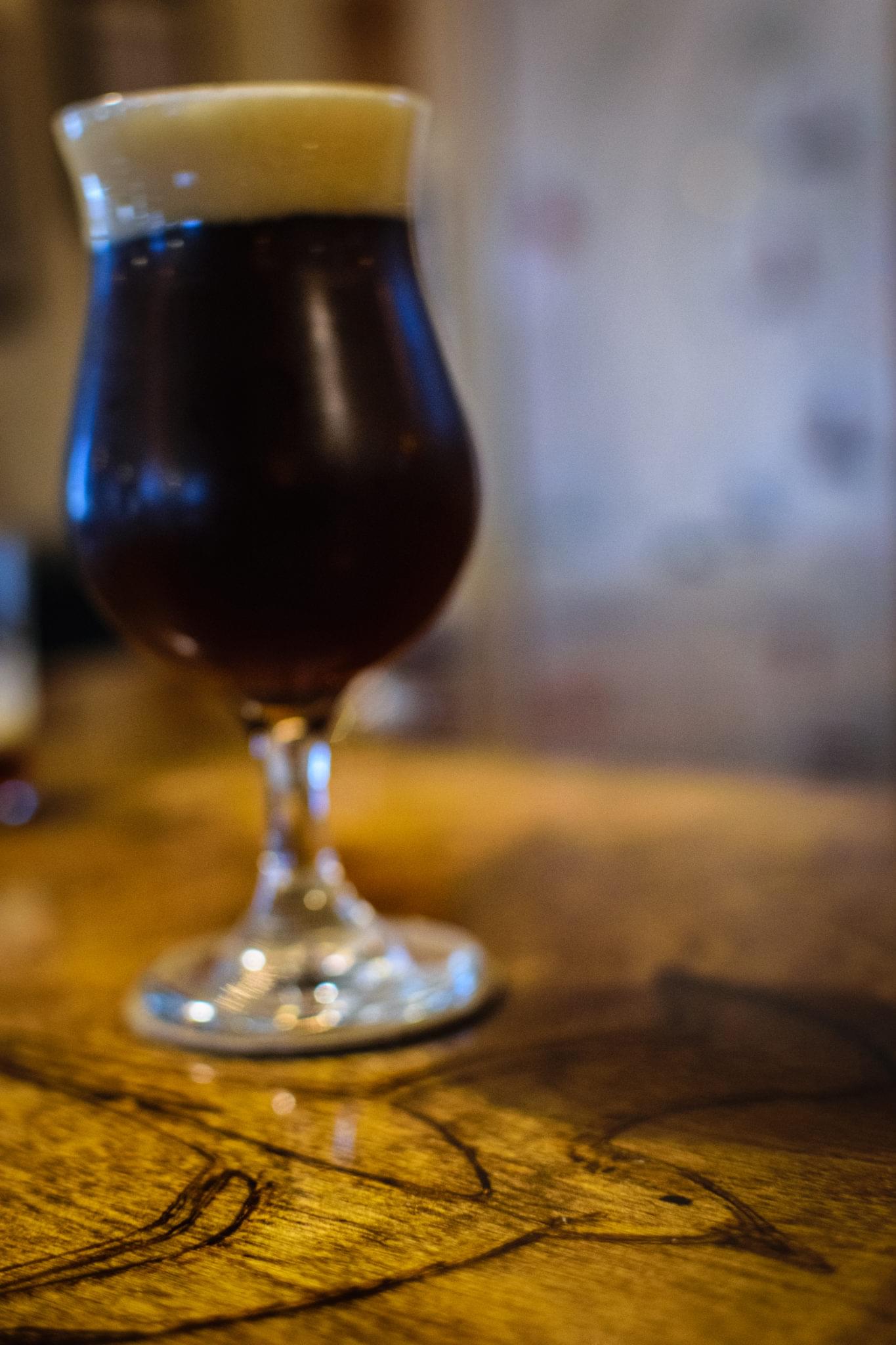 Dark craft beer served in a stemmed glass on a wooden table