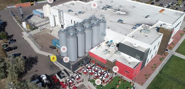 interctive-coverage-map-breweries-medium Aerial view of a brewery facility with large fermentation tanks and production buildings